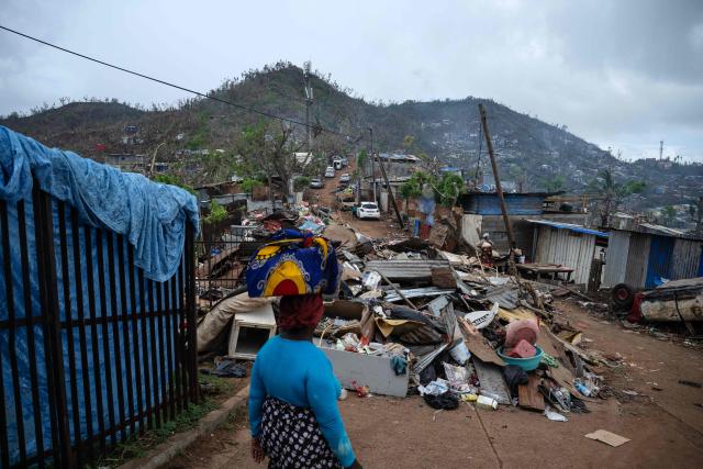 A woman walks amidst destroyed houses in shanty town of a Cavani south district damaged by the cyclone Chido in the city of Mamoudzou, on the French Indian Ocean territory of Mayotte, on January 2, 2025. The most devastating cyclone to hit Mayotte in 90 years caused colossal damage on December 14, 2024 in France's poorest department. (Photo by JULIEN DE ROSA / AFP)