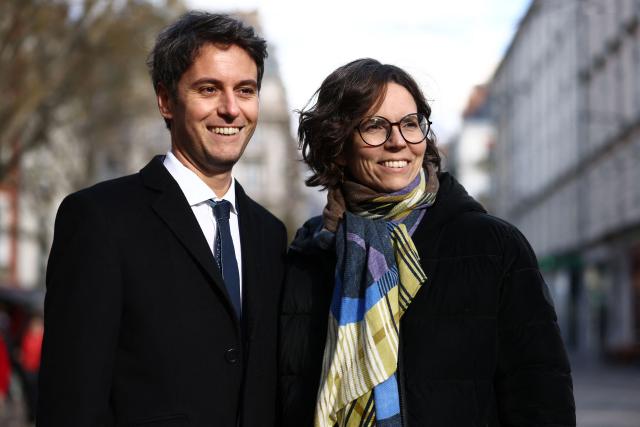 (FILES) President of Ensemble Pour la Republique parliamentary group Gabriel Attal (L) takes part in a campaign to support the candidate of French right-wing Ensemble coalition Camille Galliard-Minier (R), ahead of the partial legislative election, at a local market in Grenoble, central France, on December 20, 2024. A legislative by-election on January 12 and 19, 2025 in Isere will see LFI and Macronist candidates go head-to-head, as they did in July, but with new headliners following the resignation of the outgoing Insoumis MP and in the absence of Olivier Veran. (Photo by Alex MARTIN / AFP)