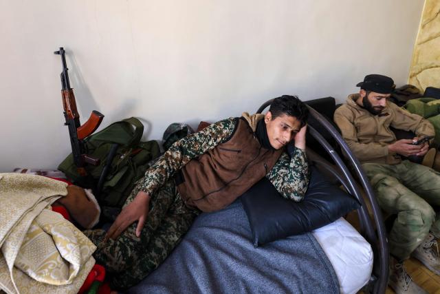 Fighters affiliated with Syria's new administration rest inside the defunct Mezzeh military prison in Damascus on January 2, 2025. (Photo by ANWAR AMRO / AFP)