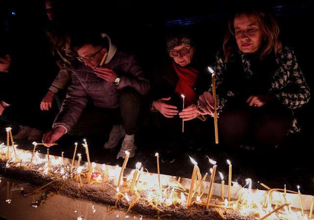 Local residents light candles during national days of mourning in Podgorica on January 2, 2025, after a gunman killed 12 people including two children in a shooting rampage that started in a restaurant. Montenegro began on January 2, 2025 three days of national mourning, a day after a gunman killed 12 people including two children. The 45-year-old attacker died after shooting himself in the head when he was surrounded following an hours-long manhunt, police said. (Photo by SAVO PRELEVIC / AFP)