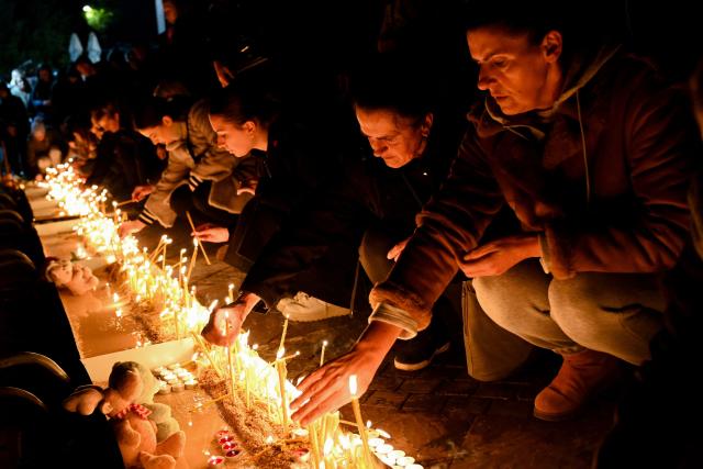 Local residents light candles during national days of mourning in Podgorica on January 2, 2025, after a gunman killed 12 people including two children in a shooting rampage that started in a restaurant. Montenegro began on January 2, 2025 three days of national mourning, a day after a gunman killed 12 people including two children. The 45-year-old attacker died after shooting himself in the head when he was surrounded following an hours-long manhunt, police said. (Photo by SAVO PRELEVIC / AFP)