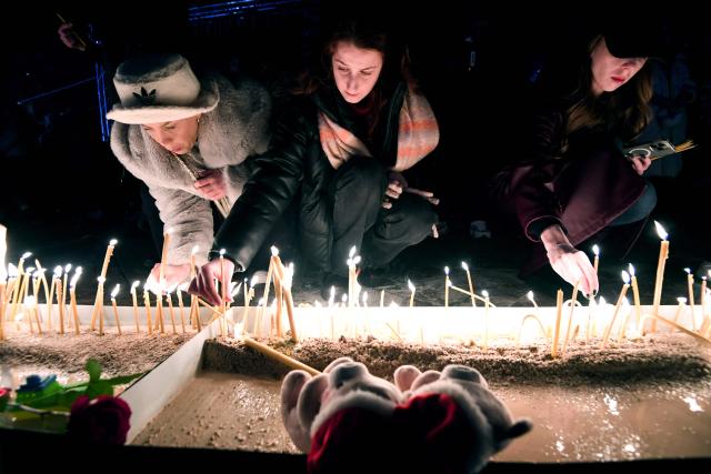 Local residents light candles during national days of mourning in Podgorica on January 2, 2025, after a gunman killed 12 people including two children in a shooting rampage that started in a restaurant. Montenegro began on January 2, 2025 three days of national mourning, a day after a gunman killed 12 people including two children. The 45-year-old attacker died after shooting himself in the head when he was surrounded following an hours-long manhunt, police said. (Photo by SAVO PRELEVIC / AFP)