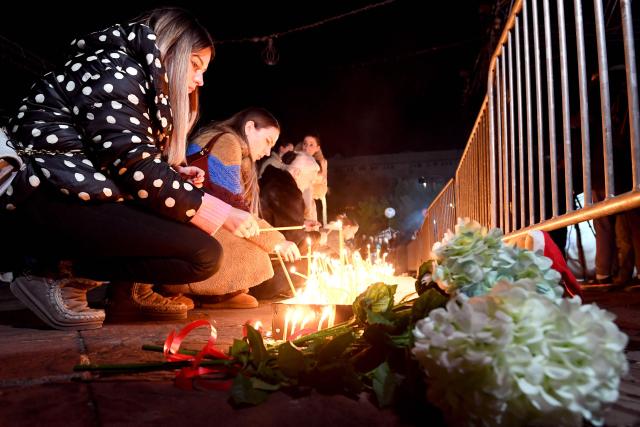 Local residents light candles during national days of mourning in Podgorica on January 2, 2025, after a gunman killed 12 people including two children in a shooting rampage that started in a restaurant. Montenegro began on January 2, 2025 three days of national mourning, a day after a gunman killed 12 people including two children. The 45-year-old attacker died after shooting himself in the head when he was surrounded following an hours-long manhunt, police said. (Photo by SAVO PRELEVIC / AFP)