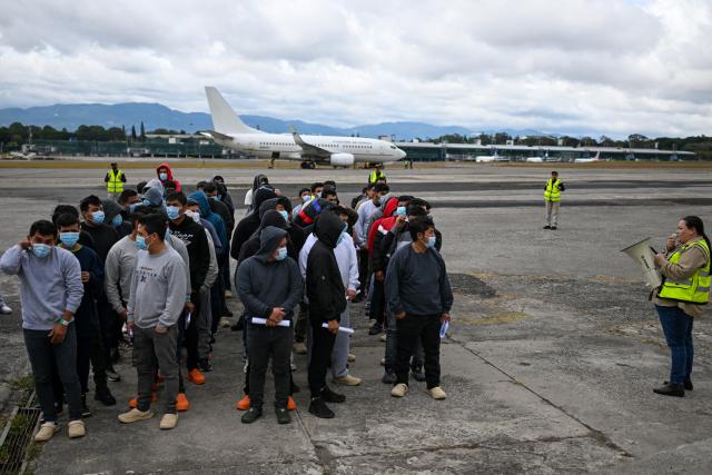 Guatemalan migrants deported from the United States stand in formation on the runway after arriving at the Guatemalan Air Force Base in Guatemala City on January 2, 2025, during the first deportee flight of the year. Guatemala closes 2024 with more than 61,000 deported from the US. (Photo by JOHAN ORDONEZ / AFP)