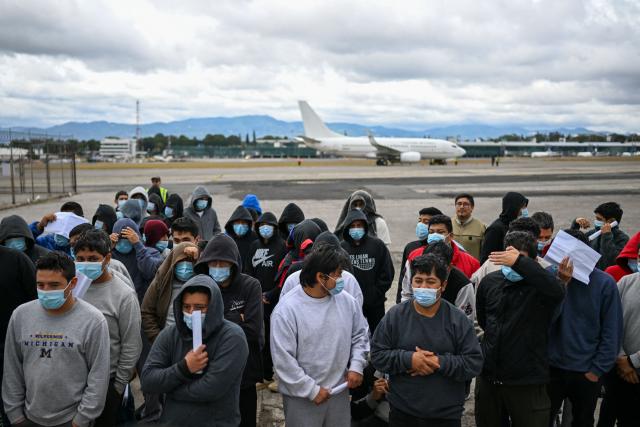 Guatemalan migrants deported from the United States stand in formation on the runway after arriving at the Guatemalan Air Force Base in Guatemala City on January 2, 2025, during the first deportee flight of the year. Guatemala closes 2024 with more than 61,000 deported from the US. (Photo by JOHAN ORDONEZ / AFP)