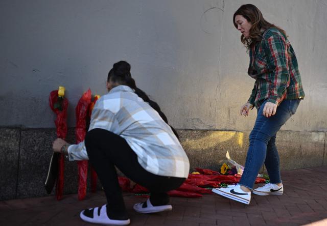 People arrange a memorial of flowers on Bourbon Street after it reopened to the public on January 2, 2025 in New Orleans, Louisiana, following a terrorist attack on January 1. At least 15 people were killed and 30 injured on January 1 when a vehicle plowed overnight into a New Year's crowd in the heart of the thriving New Orleans tourist district, authorities in the southern US city said. (Photo by ANDREW CABALLERO-REYNOLDS / AFP)