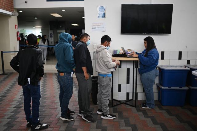 Guatemalan migrants deported from the United States wait in line to be assisted at the Returnee Reception Center upon arrival at the Guatemalan Air Force Base in Guatemala City on January 2, 2025, during the first deportee flight of the year. Guatemala closes 2024 with more than 61,000 deported from the US. (Photo by JOHAN ORDONEZ / AFP)