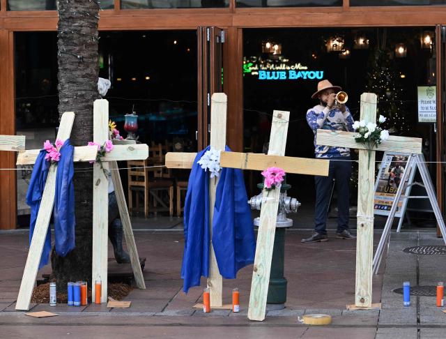 A man plays trumpet near crosses set up as a memorial near Bourbon Street on January 2, 2025 in New Orleans, Louisiana, the day after an attack by a man driving a truck down Bourbon street in the French Quarter. At least 15 people were killed and 30 injured on January 1 when a vehicle plowed overnight into a New Year's crowd in the heart of the thriving New Orleans tourist district, authorities in the southern US city said. (Photo by ANDREW CABALLERO-REYNOLDS / AFP)