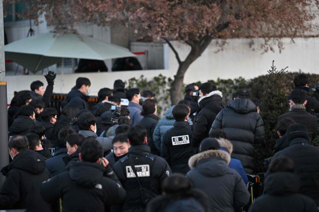 Police and anti-corruption investigators arrive at the residence of South Korea's impeached President Yoon Suk Yeol in Seoul on January 3, 2025. South Korean investigators arrived outside the presidential residence early Friday seeking to arrest Yoon Suk Yeol, with the impeached leader's die-hard supporters massing outside to protect him, AFP reporters saw. Cars carrying investigators probing Yoon's short-lived declaration of martial law drove up to his residence in central Seoul, which was surrounded by a heavy police presence, AFP saw. Yoon would become the first sitting president in South Korean history to be arrested. (Photo by JUNG Yeon-je / AFP)