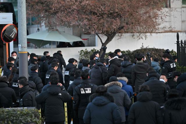 Police and anti-corruption investigators arrive at the residence of South Korea's impeached President Yoon Suk Yeol in Seoul on January 3, 2025. South Korean investigators arrived outside the presidential residence early Friday seeking to arrest Yoon Suk Yeol, with the impeached leader's die-hard supporters massing outside to protect him, AFP reporters saw. Cars carrying investigators probing Yoon's short-lived declaration of martial law drove up to his residence in central Seoul, which was surrounded by a heavy police presence, AFP saw. Yoon would become the first sitting president in South Korean history to be arrested. (Photo by JUNG Yeon-je / AFP)