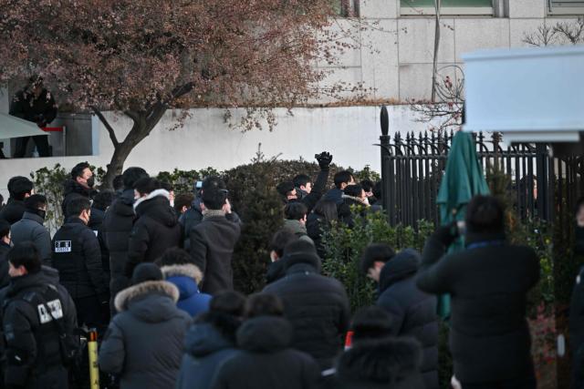 Police and anti-corruption investigators arrive at the residence of South Korea's impeached President Yoon Suk Yeol in Seoul on January 3, 2025. South Korean investigators arrived outside the presidential residence early Friday seeking to arrest Yoon Suk Yeol, with the impeached leader's die-hard supporters massing outside to protect him, AFP reporters saw. Cars carrying investigators probing Yoon's short-lived declaration of martial law drove up to his residence in central Seoul, which was surrounded by a heavy police presence, AFP saw. Yoon would become the first sitting president in South Korean history to be arrested. (Photo by JUNG Yeon-je / AFP)