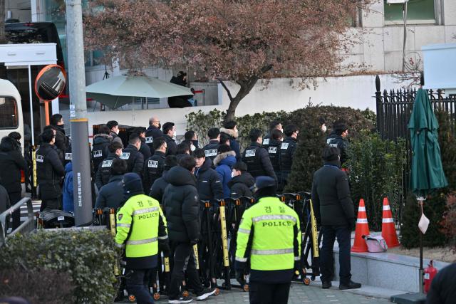 Police and anti-corruption investigators arrive at the residence of South Korea's impeached President Yoon Suk Yeol in Seoul on January 3, 2025. South Korean investigators arrived outside the presidential residence early Friday seeking to arrest Yoon Suk Yeol, with the impeached leader's die-hard supporters massing outside to protect him, AFP reporters saw. Cars carrying investigators probing Yoon's short-lived declaration of martial law drove up to his residence in central Seoul, which was surrounded by a heavy police presence, AFP saw. Yoon would become the first sitting president in South Korean history to be arrested. (Photo by JUNG Yeon-je / AFP)