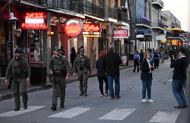 Police walking down Bourbon Street past reporters on January 2, 2025 in New Orleans, Louisiana, the day after an attack by a man driving a truck down Bourbon street in the French Quarter. At least 15 people were killed and 30 injured on January 1 when a vehicle plowed overnight into a New Year's crowd in the heart of the thriving New Orleans tourist district, authorities in the southern US city said. (Photo by ANDREW CABALLERO-REYNOLDS / AFP)