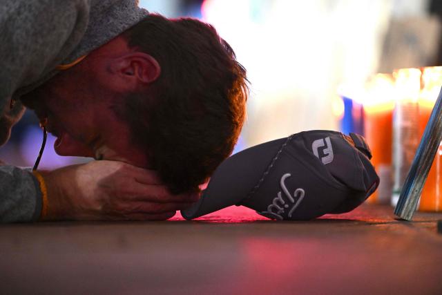 A man reacts at a memorial set up on Bourbon Street on January 2, 2025 in New Orleans, Louisiana, the day after an attack by a man driving a truck down Bourbon street in the French Quarter. A US army veteran loyal to the Islamic State jihadist group likely acted alone when he killed 14 and injured dozens in a truck attack on a crowd of New Year revelers in New Orleans, the FBI said Thursday. Despite initial concerns that Shamsud-Din Jabbar, 42, had accomplices still on the run, preliminary investigations show he likely acted alone, FBI deputy assistant director Christopher Raia said. (Photo by ANDREW CABALLERO-REYNOLDS / AFP)