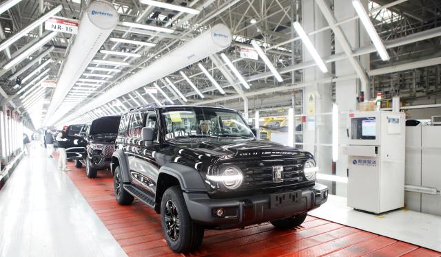 This photo taken on January 2, 2024 shows newly-finished cars rolling off the production line at the Great Wall Motors' Chongqing smart factory in southwest China's Chongqing, marking the completion of the factory's one-millionth vehicle. (Photo by AFP) / China OUT