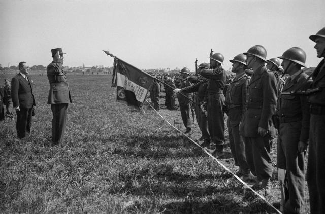 (FILES) French President of the Provisional Government of the French Republic General Charles de Gaulle salutes the flag of the French 158th Infantry Regiment (158th RI), known as the “Lorette Regiment”, during a military review of troops composed of thousands of soldiers and resistance fighters who participated in the Liberation of the city of Royan, on April 22, 1945 in the Mathes plain in Arvert near Royan, western France. On January 5, 1945, Royan lay in ruins, the victim of a night-time deluge of Allied bombs that had killed 442 civilians: a series of misunderstandings and misfires had led to the destruction of the Charente coastal town, still held by the Germans. (Photo by Roger Parry / AFP)