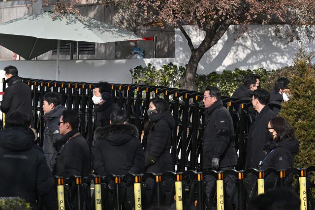 Anti-corruption investigators leave the residence of South Korea's impeached President Yoon Suk Yeol in Seoul on January 3, 2025 after calling off their attempt to arrest Yoon. South Korea investigators called off their attempt to arrest impeached President Yoon Suk Yeol at his residence on January 3 over a failed martial law bid, citing safety concerns after a standoff with his security team. (Photo by JUNG Yeon-je / AFP)