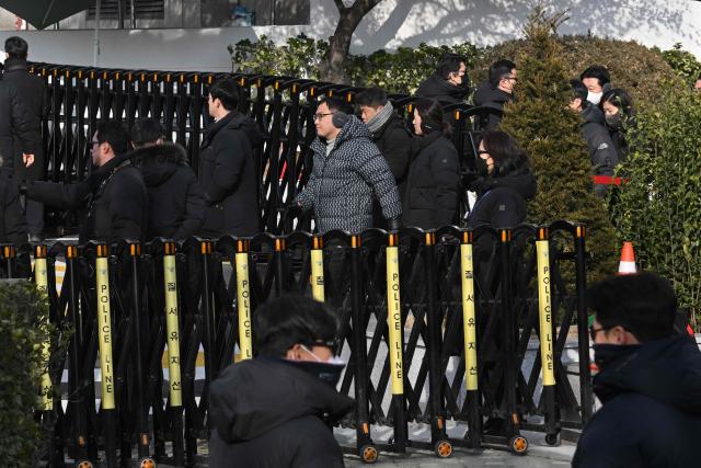 Anti-corruption investigators leave the residence of South Korea's impeached President Yoon Suk Yeol in Seoul on January 3, 2025 after calling off their attempt to arrest Yoon. South Korean investigators called off their attempt to arrest impeached President Yoon Suk Yeol at his residence Friday over a failed martial law bid, citing safety concerns after a standoff with his security team. (Photo by JUNG Yeon-je / AFP)