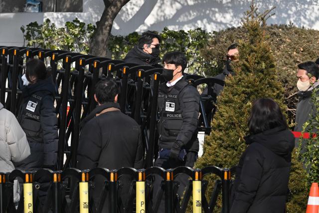 Police leave the residence of South Korea's impeached President Yoon Suk Yeol in Seoul on January 3, 2025 after calling off their attempt to arrest Yoon. South Korea investigators called off their attempt to arrest impeached President Yoon Suk Yeol at his residence on January 3 over a failed martial law bid, citing safety concerns after a standoff with his security team. (Photo by JUNG Yeon-je / AFP)