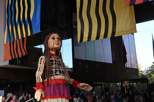 Little Amal, a 12-foot-tall puppet representing a ten-year-old Syrian refugee, is seen during a performance at the Gabriel Mistral Cultural Center as part of the opening of the 32nd version of the International Festival Teatro a Mil in Santiago on January 3, 2025. Santiago a Mil International Theatre Festival is an annual performing arts festival that takes place in January in Santiago, Chile. It is the largest arts festival in Chile and includes theatre, dance, and music events from Chile and abroad, performed in the capital city, Santiago, and around the country. (Photo by RODRIGO ARANGUA / AFP)