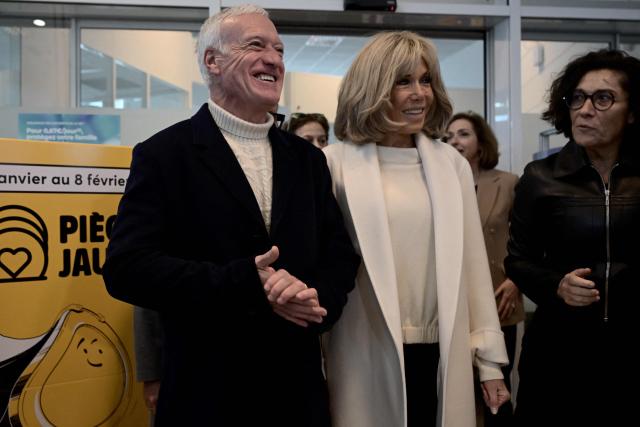 French national football team's head coach Didier Deschamps (L) and French President's wife Brigitte Macron stand outside Bordeaux's main post office in Bordeaux, southwestern France, on January 8, 2025, as they launch the 2025 edition of the charity fund called "Operations pieces jaunes" (operation yellow coins), with its foundation aiming to improve the conditions of hospitalized children. France's 2018 World Cup-winning head coach Didier Deschamps announced on January 8, 2025 he will leave his post after the 2026 finals. (Photo by Philippe Lopez / AFP)