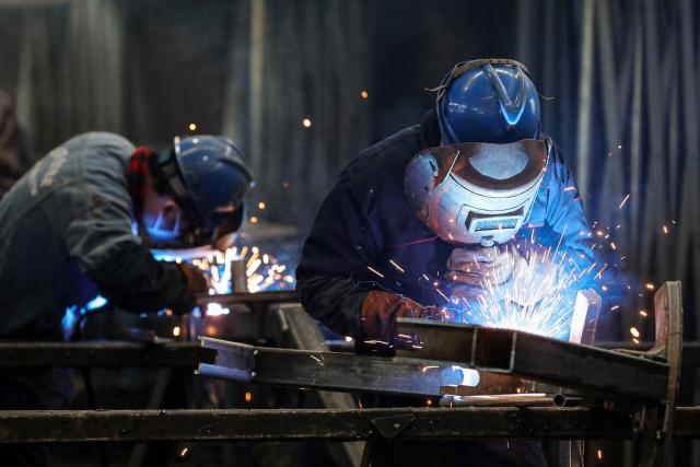 Employees weld parts at a factory producing mining equipment in Huaibei, in eastern China's Anhui province on January 9, 2025. (Photo by AFP) / China OUT