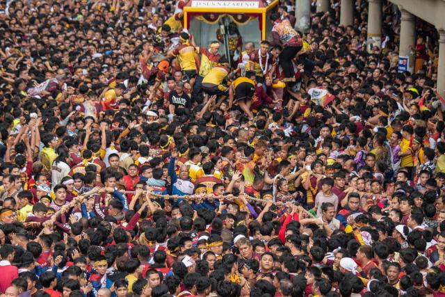 Catholic devotees jostle with each other as they try to touch the glass of a carriage carrying the statue of the Black Nazarene during the annual religious procession of the Black Nazarene in Manila on January 9, 2025. Hundreds of thousands of Catholic pilgrims swarmed the streets of Manila in search of a miracle on January 9, straining to reach a centuries-old statue of Jesus Christ in an annual display of religious fervour. (Photo by Ted ALJIBE / AFP)