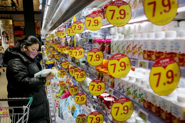 A customer shops for dairy products at a supermarket in Lianyungang, in eastern China's Jiangsu province on January 9, 2025. (Photo by AFP) / China OUT