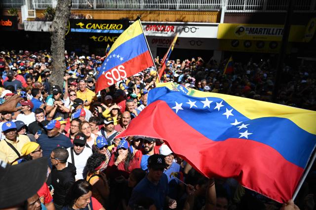 Demonstrators wave Venezuelan flags during a protest called by the opposition on the eve of the presidential inauguration in Caracas on January 9, 2025. Venezuela is on tenterhooks facing demonstrations called by both the opposition and government supporters a day before President Nicolas Maduro is due to be sworn in for a third consecutive term and despite multiple countries recognizing opposition rival Edmundo Gonzalez Urrutia as the legitimate president-elect following elections past July. (Photo by Federico PARRA / AFP)