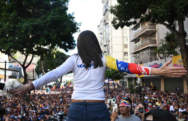 Venezuelan opposition leader Maria Corina Machado gestures as she addresses her supporters during a protest called by the opposition on the eve of the presidential inauguration in Caracas on January 9, 2025. Machado, who emerged from hiding to lead protests against the swearing-in of Nicolas Maduro for a highly controversial third term as president, was arrested after being "violently intercepted upon exiting the rally," according to her security team. (Photo by Federico PARRA / AFP)