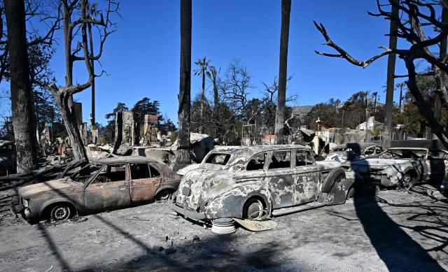 Burned-out antique cars by the Eaton Fire are seen in Altadena, California, on January 13, 2025. Homeowners and renters who lost their homes due to the fire are suing Southern California Edison, alleging the electrical utility that provides electricity to some 15 million people in a 50,000 square-mile area of Southern California failed to de-energize its electrical equipment despite the high wind and red flag warnings issues by the National Weather Service. (Photo by Frederic J. BROWN / AFP)