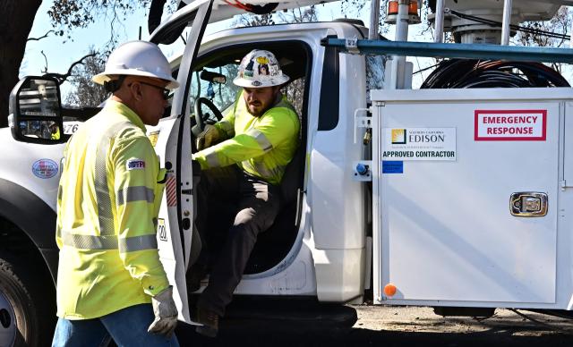 A Southern California Edison worker steps out of his vehicle on January 13, 2025 in Altadena, California, where the devastating Eaton Fire caused widespread damage. Homeowners and renters who lost their homes due to the fire are suing Southern California Edison, alleging the electrical utility that provides electricity to some 15 million people in a 50,000 square-mile area of Southern California failed to de-energize its electrical equipment despite the high wind and red flag warnings issues by the National Weather Service. (Photo by Frederic J. BROWN / AFP)