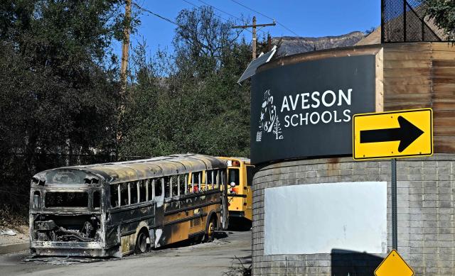 A burnt out schoolbus is seen at the fire-damaged Aveson Charter School from the aftermath of the Eaton Fire in Altadena, California on January 13, 2025. Homeowners and renters who lost their homes due to the fire are suing Southern California Edison, alleging the electrical utility that provides electricity to some 15 million people in a 50,000 square-mile area of Southern California failed to de-energize its electrical equipment despite the high wind and red flag warnings issues by the National Weather Service. (Photo by Frederic J. BROWN / AFP)