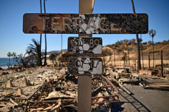 A street sign is pictured in the fire-ravaged Pacific Palisades Bowl Mobile Estates in Los Angeles, California, on January 13, 2025. Firefighters were battling massive wildfires on January 13 that have ravaged Los Angeles and killed at least 24 people, with officials warning of incoming dangerous winds that could whip up the blazes further. (Photo by AGUSTIN PAULLIER / AFP)