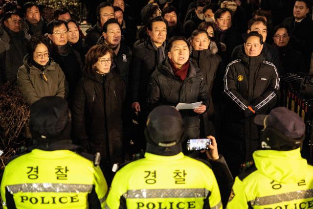 Kim Gi-hyeon (front, 2nd L), a lawmaker of the People Power Party (PPP), addresses the media as authorities try to detain impeached South Korean President Yoon Suk Yeol near his residence in Seoul on January 15, 2025. Yoon was arrested on January 15 over his failed martial law bid, after hundreds of anti-graft investigators and police raided his residence to end a weeks-long standoff. (Photo by YASUYOSHI CHIBA / AFP)