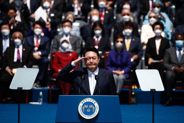 (FILES) South Korea's new President Yoon Suk-yeol salutes during his inauguration in front of the National Assembly in Seoul on May 10, 2022. Impeached South Korean leader Yoon Suk Yeol was arrested on January 15, 2025 over his failed martial law bid, ending a weeks-long standoff with authorities and becoming the first president to be detained in the nation's history. (Photo by JEON HEON-KYUN / POOL / AFP)