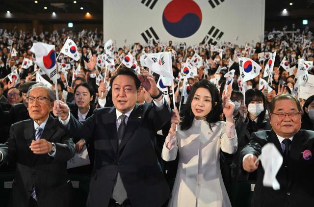 (FILES) South Korea's President Yoon Suk Yeol (2nd L) and his wife Kim Keon Hee (2nd R) give three cheers during a ceremony marking the 104th anniversary of the March 1st Independence Movement Day against Japanese colonial rule, in Seoul on March 1, 2023. Impeached South Korean leader Yoon Suk Yeol was arrested on January 15, 2025 over his failed martial law bid, ending a weeks-long standoff with authorities and becoming the first president to be detained in the nation's history. (Photo by JUNG YEON-JE / POOL / AFP)