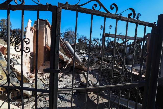 The entrance of Laeticia Hallyday's house is seen after being destroyed by the Palisades Fire, on January 14, 2025, in Pacific Palisades, California. Powerful winds forecast for late January 14 threatened to whip up massive fires that are still burning around Los Angeles in a tragedy that has killed at least 25 people and badly shaken the city. (Photo by VALERIE MACON / AFP)