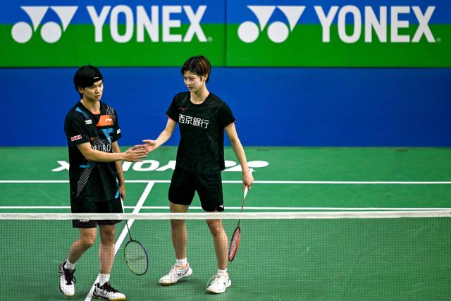 Japan's Maya Taguchi (R) and Yuta Watanabe gesture as they play against Malaysia’s Wong Tien Ci and Lim Chiew Sien during their mixed doubles match at the Yonex-Sunrise India Open 2025 badminton tournament in New Delhi on January 15, 2025. (Photo by Money SHARMA / AFP)