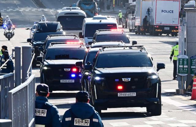 A motorcade carrying impeached South Korea President Yoon Suk Yeol arrives at the complex building housing the Corruption Investigation Office for High-ranking Officials (CIO) in Gwacheon on January 15, 2025, after Yoon was arrested over his failed martial law bid. (Photo by KOREA POOL / AFP) / South Korea OUT