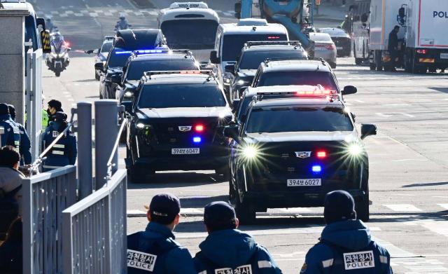 A motorcade carrying impeached South Korea President Yoon Suk Yeol arrives at the complex building housing the Corruption Investigation Office for High-ranking Officials (CIO) in Gwacheon on January 15, 2025, after Yoon was arrested over his failed martial law bid. (Photo by KOREA POOL / AFP) / South Korea OUT