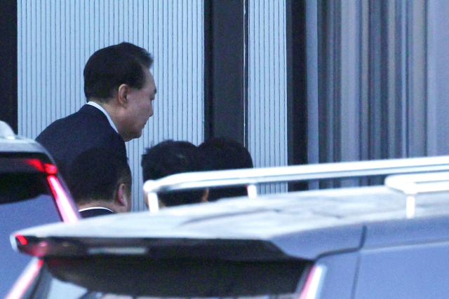 South Korean impeached President Yoon Suk Yeol arrives at the complex building housing the Corruption Investigation Office for High-ranking Officials (CIO) in Gwacheon on January 15, 2025. Yoon was arrested on January 15 over his failed martial law bid, after hundreds of anti-graft investigators and police raided his residence to end a weeks-long standoff. (Photo by KOREA POOL / AFP) / South Korea OUT