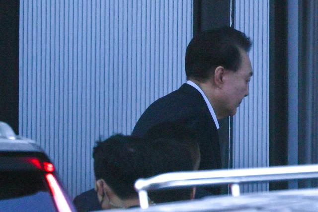 South Korean impeached President Yoon Suk Yeol arrives at the complex building housing the Corruption Investigation Office for High-ranking Officials (CIO) in Gwacheon on January 15, 2025. Yoon was arrested on January 15 over his failed martial law bid, after hundreds of anti-graft investigators and police raided his residence to end a weeks-long standoff. (Photo by KOREA POOL / AFP) / South Korea OUT