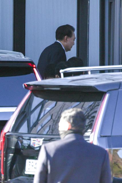 South Korean impeached President Yoon Suk Yeol arrives at the complex building housing the Corruption Investigation Office for High-ranking Officials (CIO) in Gwacheon on January 15, 2025. Yoon was arrested on January 15 over his failed martial law bid, after hundreds of anti-graft investigators and police raided his residence to end a weeks-long standoff. (Photo by KOREA POOL / AFP) / South Korea OUT