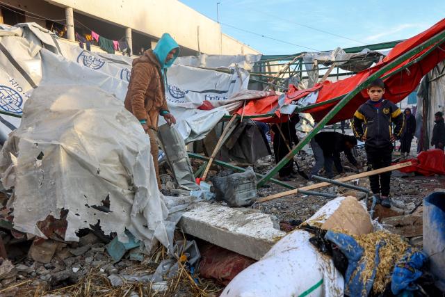 People check the destruction in the aftermath of an Israeli strike at the  Al-Farabi school in the centre of Gaza City, which is sheltering a number of displaced people, on January 15, 2025, amid the ongoing war between Israel and the militant group Hamas. (Photo by Omar AL-QATTAA / AFP)