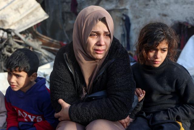 A woman cries as she watches the destruction in the aftermath of an Israeli strike at the Al-Farabi school in the centre of Gaza City, which is sheltering a number of displaced people, on January 15, 2025, amid the ongoing war between Israel and the militant group Hamas. (Photo by Omar AL-QATTAA / AFP)