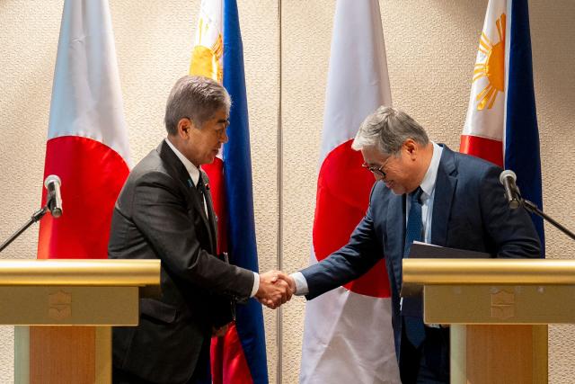 Japan's Foreign Minister Takeshi Iwaya (L) and Philippine Foreign Minister Enrique Manalo shake hands after a joint press conference in Manila on January 15, 2025. (Photo by LISA MARIE DAVID / POOL / AFP)