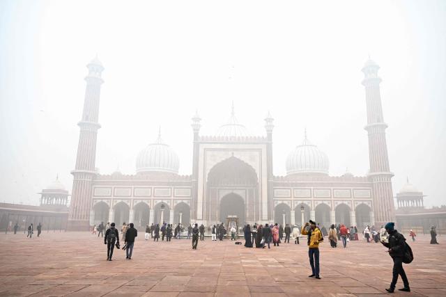 People visit the Jama Masjid (mosque) amid dense fog on a cold winter morning in the walled city area of New Delhi on January 15, 2025. (Photo by ARUN SANKAR / AFP)