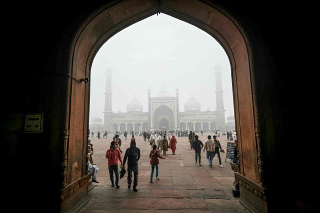 People visit the Jama Masjid (mosque) amid dense fog on a cold winter morning in the walled city area of New Delhi on January 15, 2025. (Photo by Arun SANKAR / AFP)