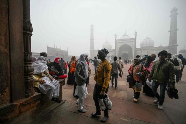 People visit the Jama Masjid (mosque) amid dense fog on a cold winter morning in the walled city area of New Delhi on January 15, 2025. (Photo by Arun SANKAR / AFP)